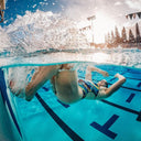 Underwater view of a swimmer in a pool with a split shot above and below water - Swimming At Private Clubs in Singapore