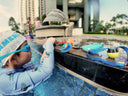 Dreamers Toddler Learn to Swim Program - Building Water Confidence in swimming lesson - Child playing with toys by a poolside during a swimming class.