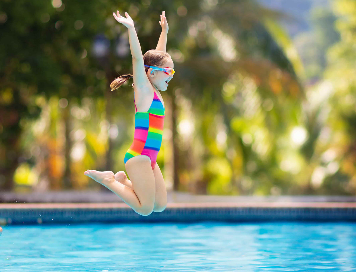Child leaping into a swimming pool during a Dreamers lesson in Singapore