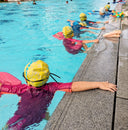 Children in swim caps and goggles in a pool - Kids Group Swimming Lessons - Swim Squad Training in Condominium Pool