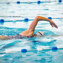 Person swimming in a pool with lane dividers - Learn to Swim at Active Sg Public Swimming Pools Singapore