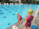 Two children in swim gear standing by a pool ready to plunge - Toddler Learn to Swim - Swim Stroke Development Singapore - Toddler Private Swimming Class in Condominium Pool Singapore