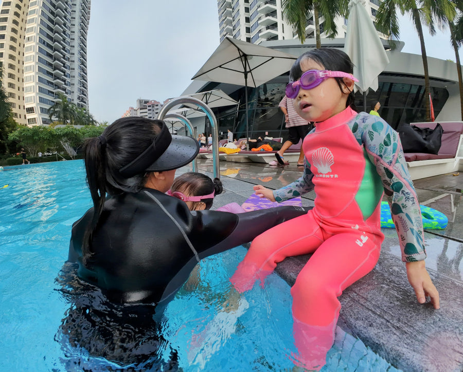 Young girls learning to swim in Singapore condo pool with Dreamers