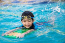 Young kid kicking and learning to float and balance - Swimming Lessons for Children Singapore